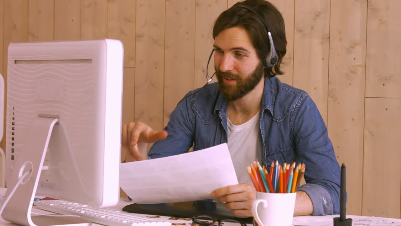 Hipster worker using video chat at desk