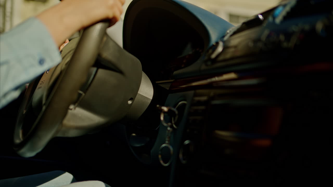 Person rotating the steering wheel while driving a car