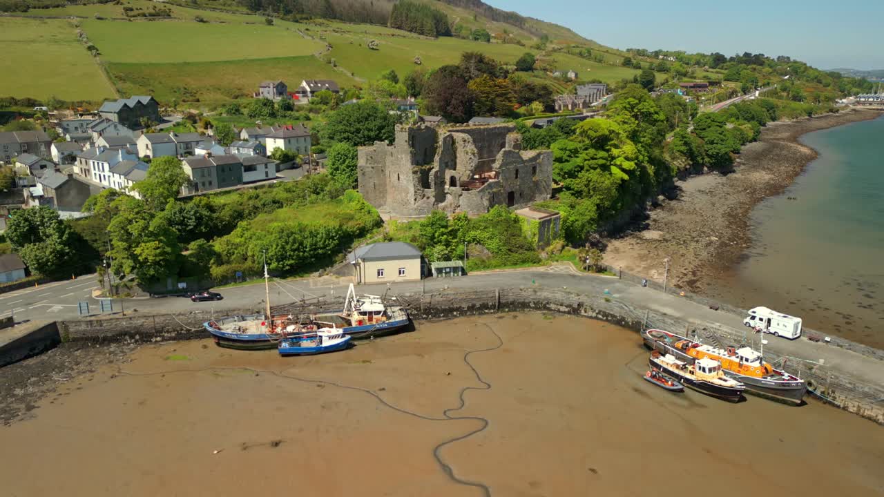 Wide reversing aerial video of Carlingford Castle on Carlingford Lough in County Louth, Ireland on a bright and sunny day. Filmed in 4K, 60FPS and with Rec709 color.