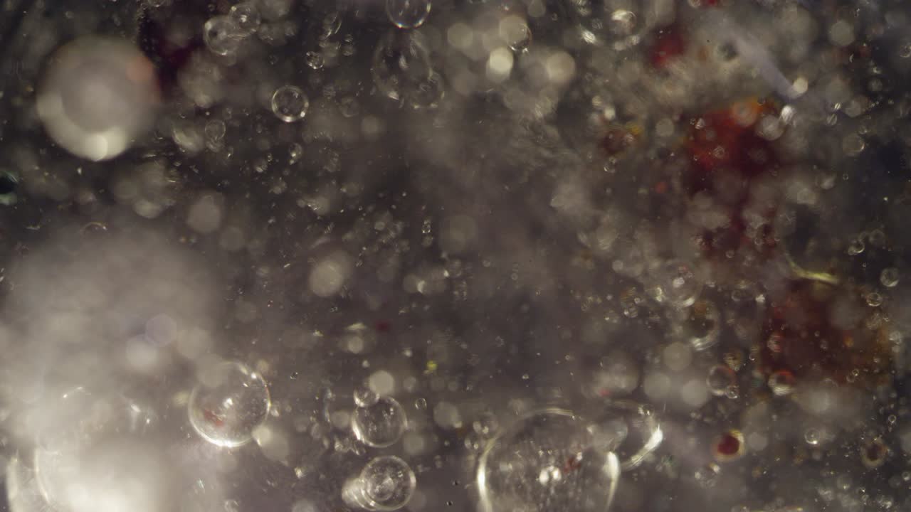 Abstract clear liquid bubbles moving with blood red liquid bokeh texture background