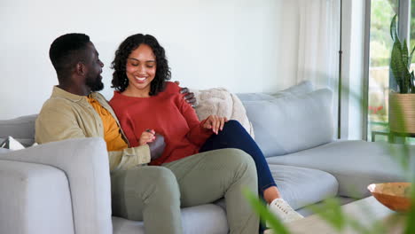happy couple relaxing on cozy sofa at home, enjoying quality time together