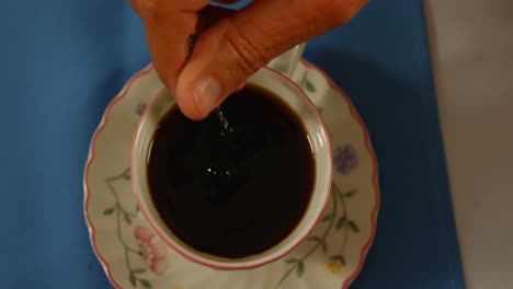 close-up of hand stirring tea