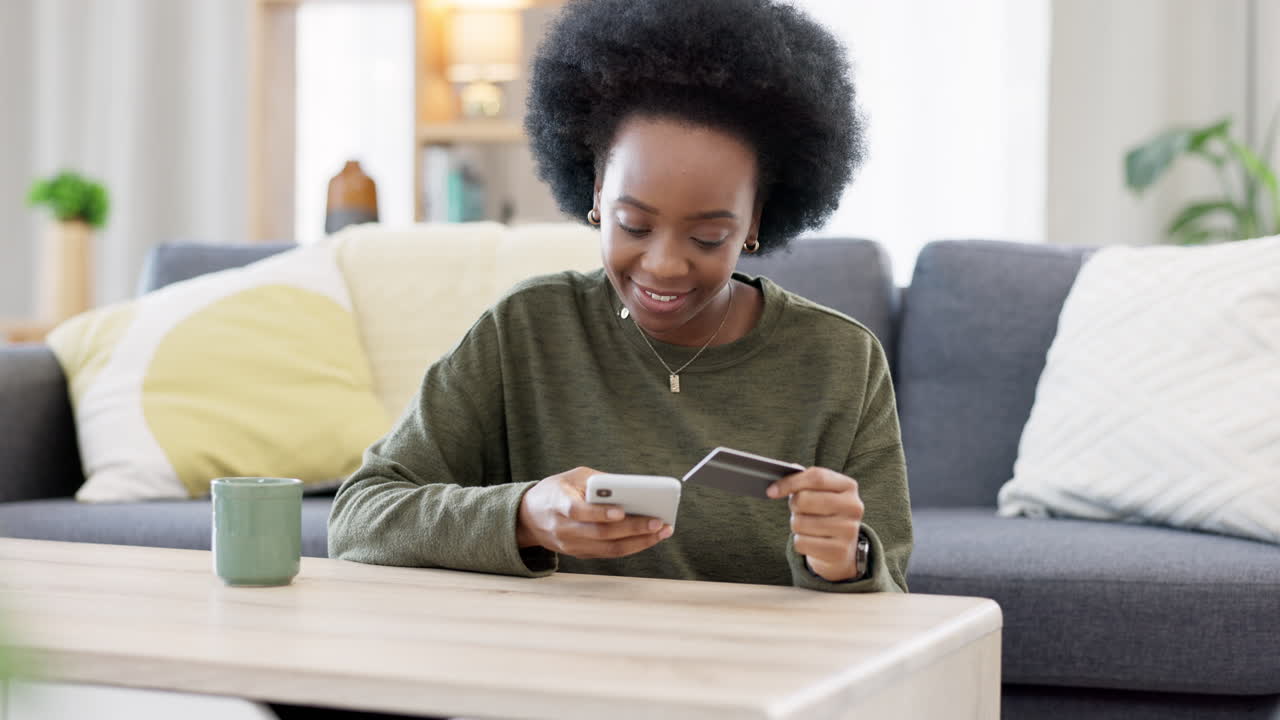 Young black woman shopping online using her phone