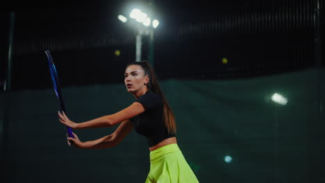 woman playing tennis at night