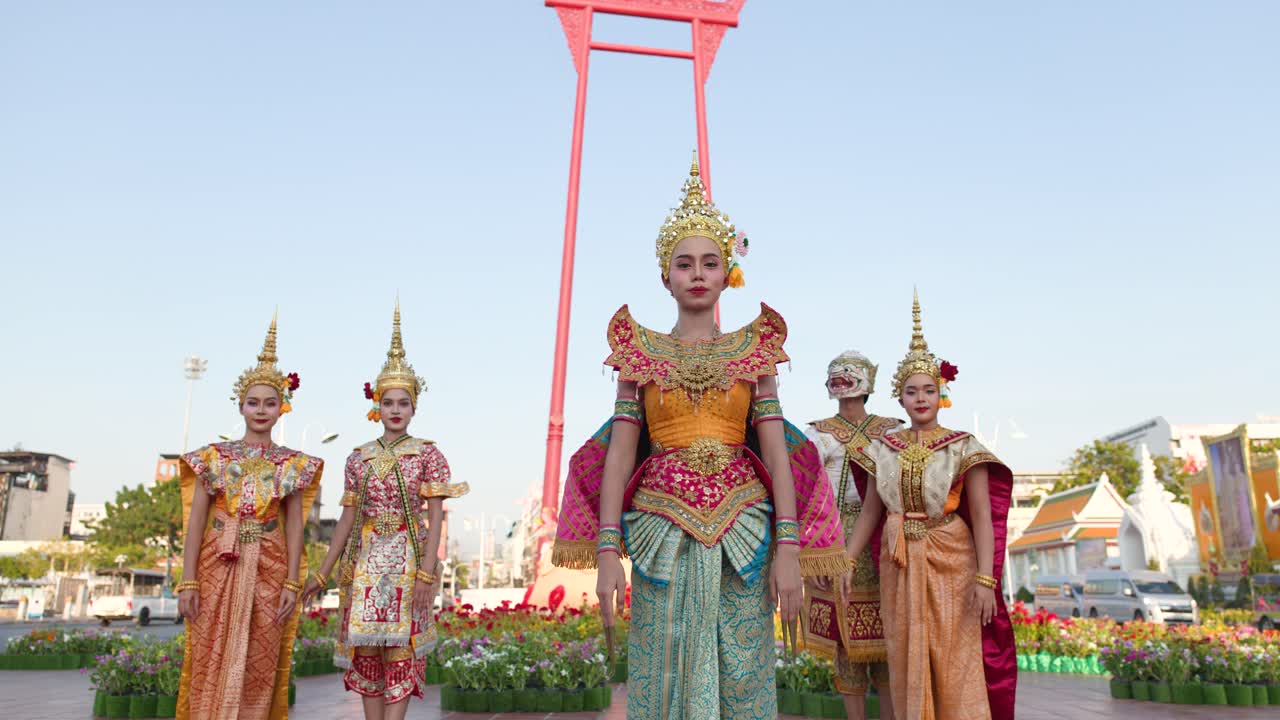 Ballerini tradizionali thailandesi Khon si esibiscono in costumi sontuosi davanti al Giant Swing a Bangkok