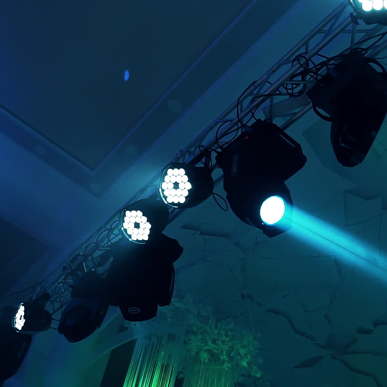 Colorful lights from projectors shining brightly from the ceiling inside the club. Flashing rays with different colors from spotlights in the nice hall.