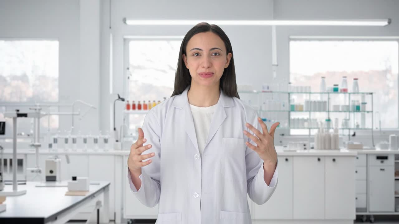 행복 한 인도 여성 과학자 가 카메라 와 대화 하고 있다