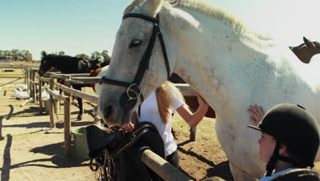 Siblings-touching-the-white-horse-in-the-ranch-4k