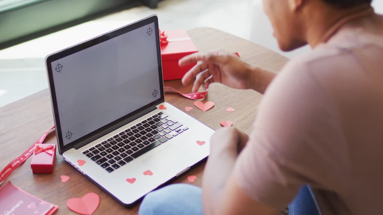 アフリカ系アメリカ人の男性が自宅でラップトップを使ってビデオコールで話しています