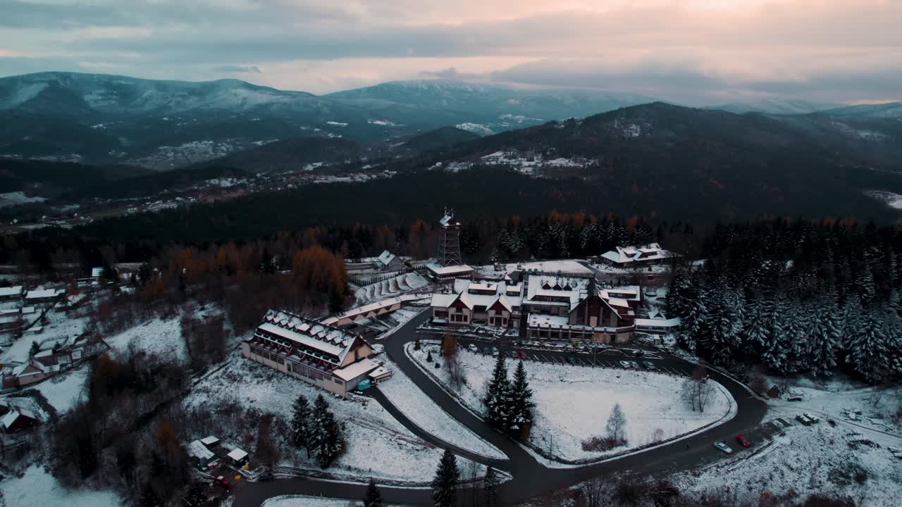 imágenes aéreas de un hotel de montaña en un paisaje montañoso durante la temporada de invierno