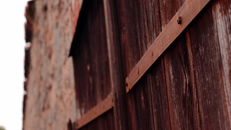 a wooden antique door with wrought iron in stone wall