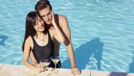 Loving-couple-smooching-at-swimming-pool