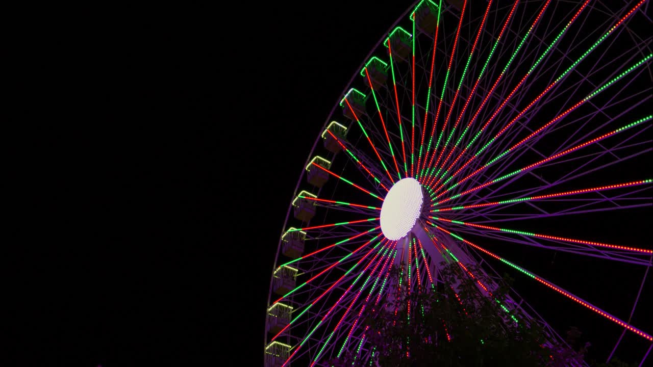 Grande roue éclatante avec des lumières LED changeantes la nuit.