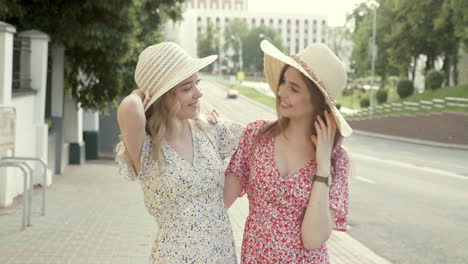 two friends wearing straw hats and floral dresses