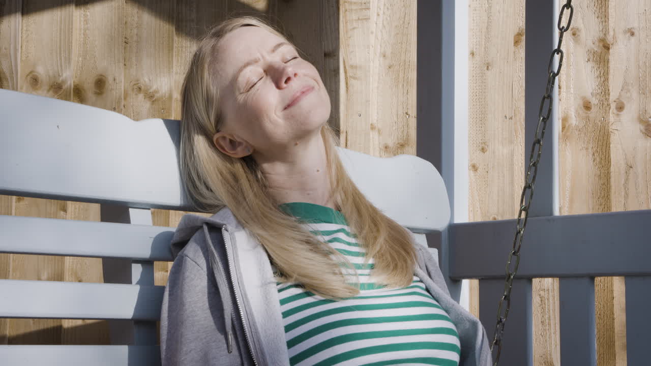 Woman relaxing on a porch swing with coffee