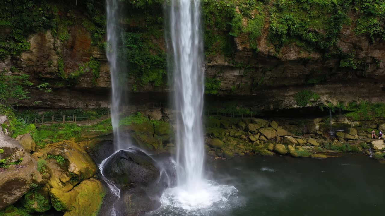 Luftaufnahme: Aufsteigender Blick auf einen hohen Wasserfall, der über einen Felsabgrund einer Schlucht stürzt