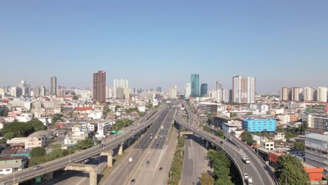 drone view above highway interchange on rama iii road with skyscraper, sideways