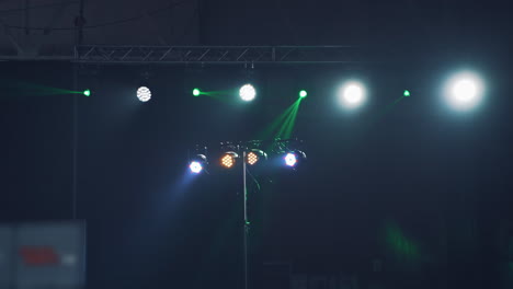 bright colors of projectors changing its lights on the scene in the nightclub. flashing lights shine from spotlights during musical concert inside.