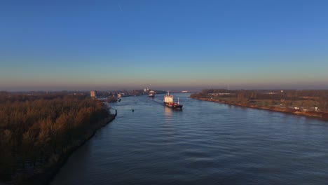 widok z powietrza dwóch dużych statków pływających nad holenderską rzeką podczas kolorowego wschodu słońca