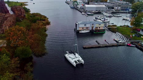 Aerial-view-of-a-yacht-sailing-back-to-the-dock-on-a-cloudy-evening