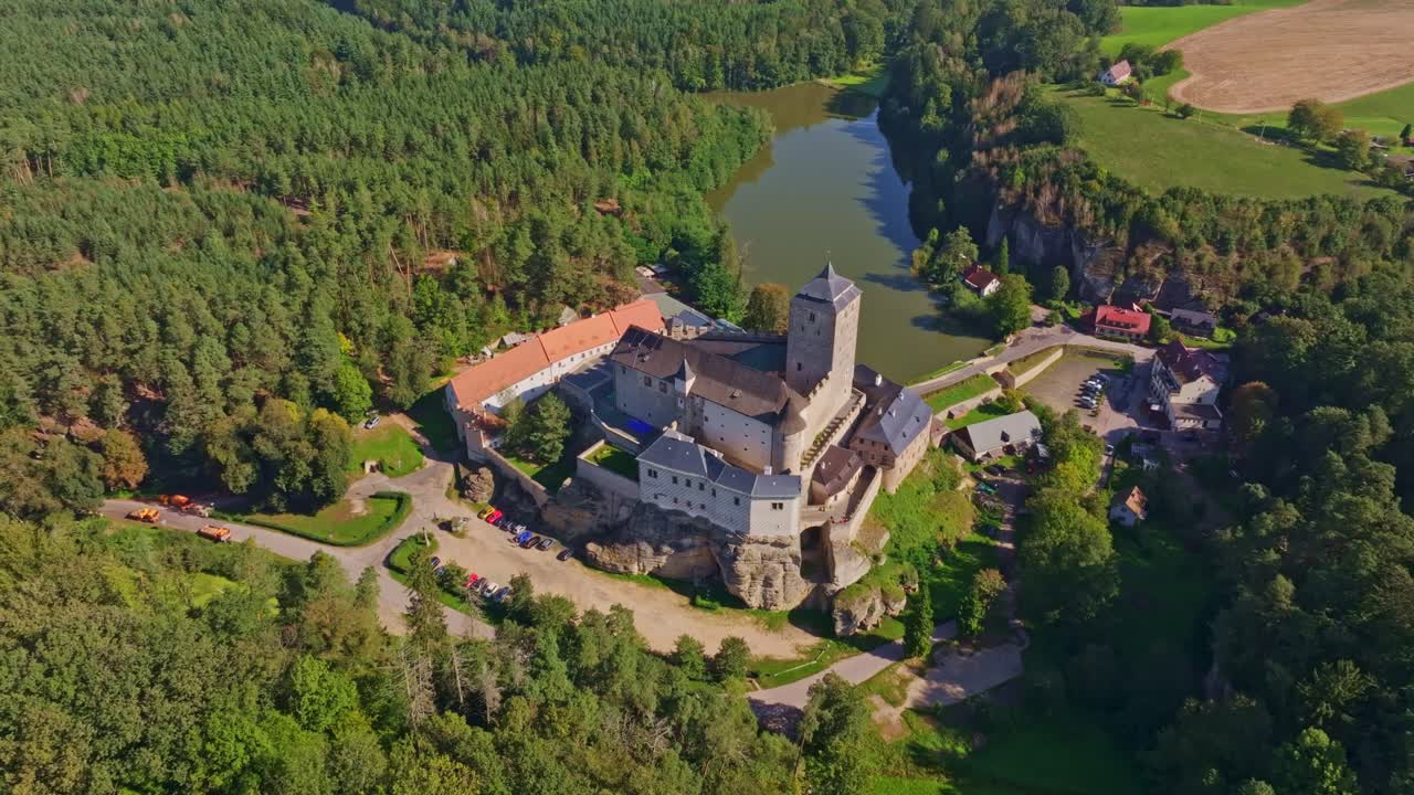 Flyperspektiv av historiske Kost slott omfavnet av tett skog