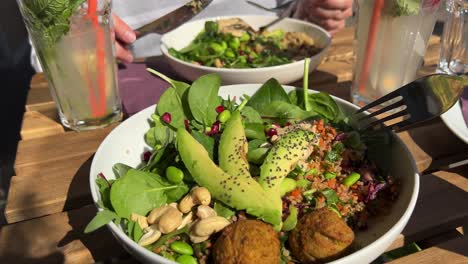 eating fresh falafel bowl with salad and avocado