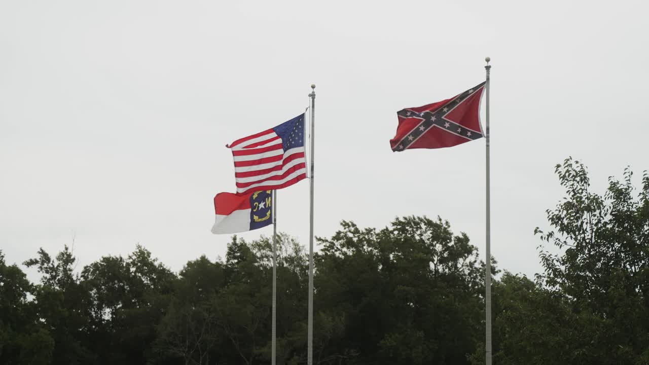 confederado, nosotros, y la bandera de carolina del norte volando sobre un campo de batalla histórico de la guerra civil