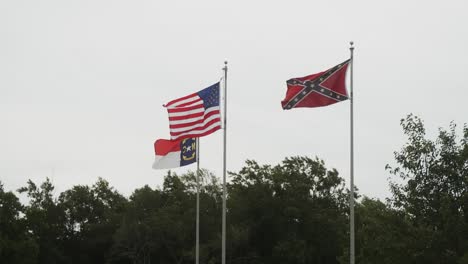 confederate, us, and north carolina flag flying over a civil war historic battlefield