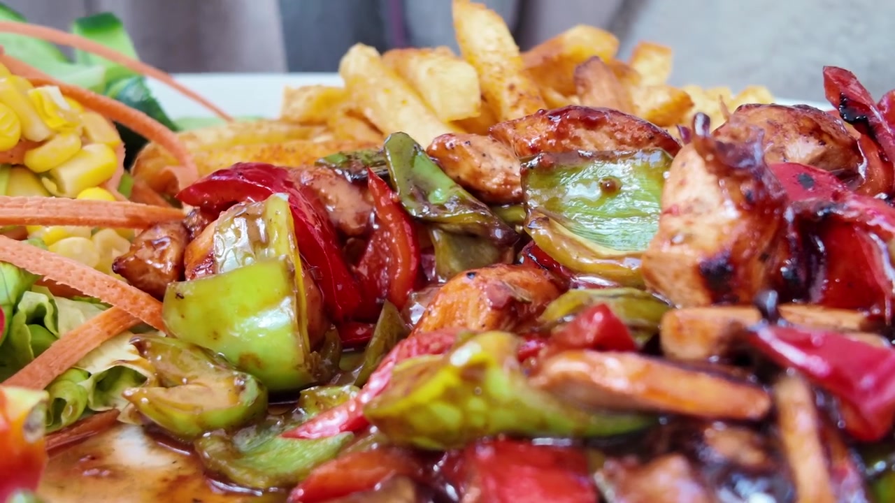 Forchetta che raccoglie pollo grigliato e verdure da un piatto