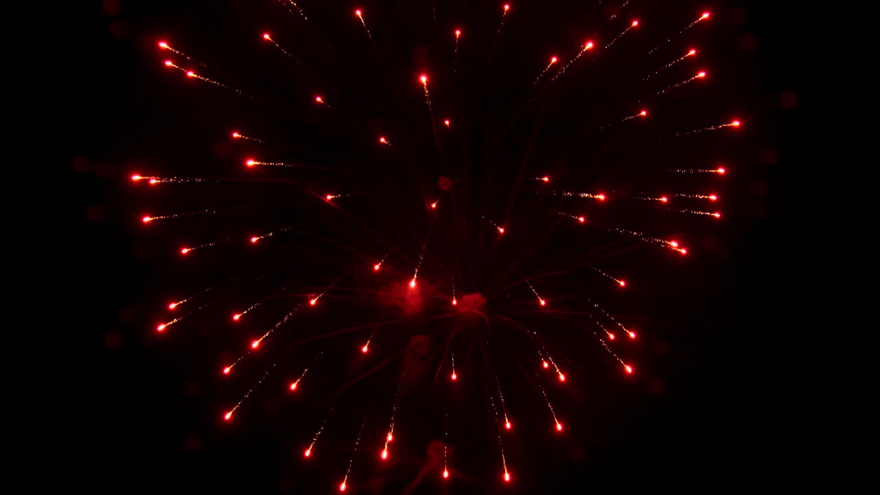 las rayas y los destellos de la noche de colores brillantes explotan e iluminan el cielo nocturno negro durante la exhibición de fuegos artificiales