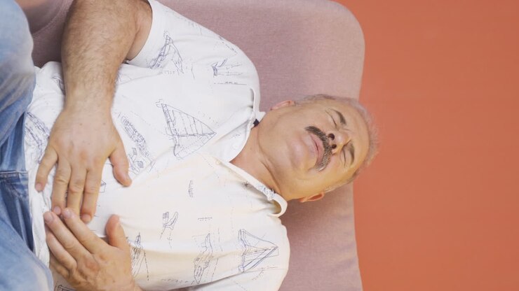 Vertical video of Old man experiencing stomachache.
