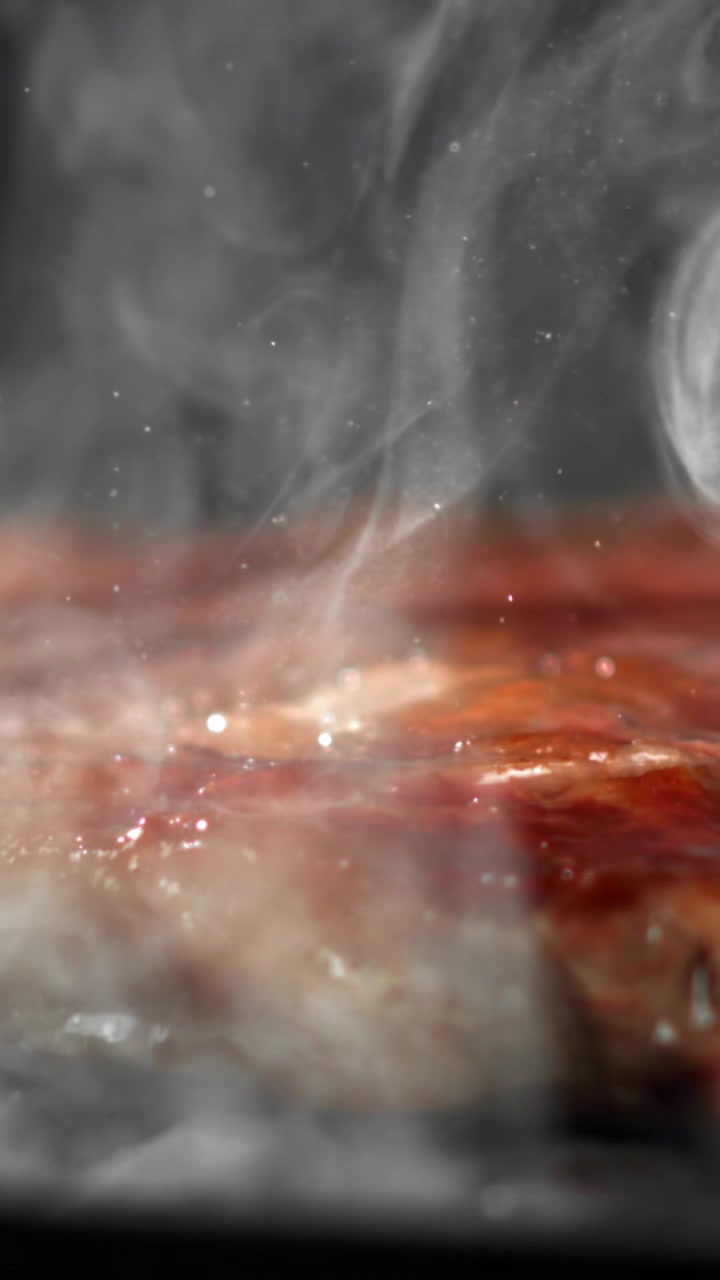Primo piano di carne che sfrigola e fuma su una superficie calda