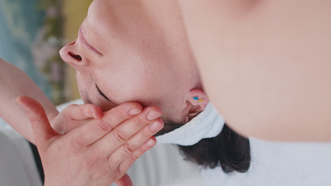 Therapist female doctor making woman relaxing spa face massage outdoors in mountains field fantasy