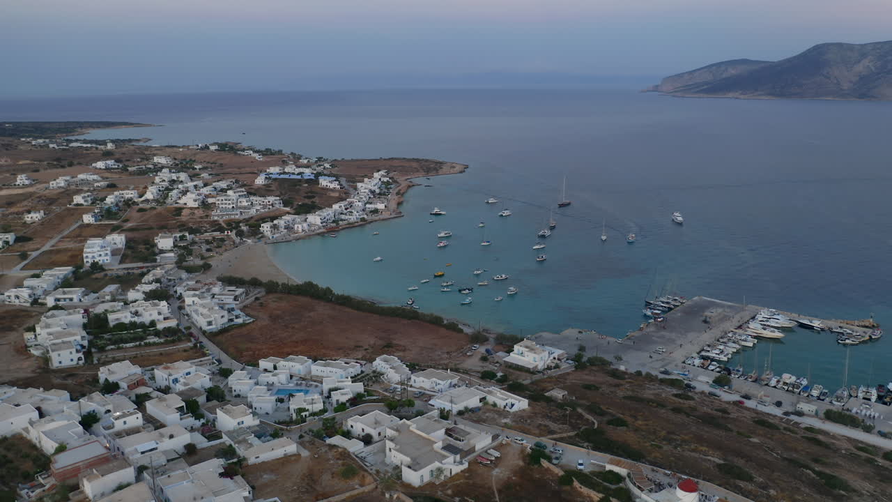 Port buildings and boats seen from above at Koufonisia Chora during warm sunset glow