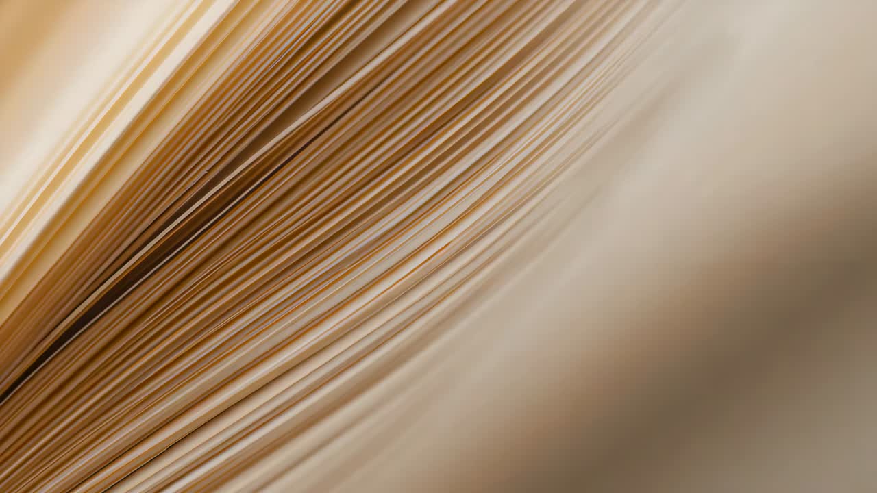 Shifting fanned deck of cream pages from slow camera shift revealing page margins on light tabletop