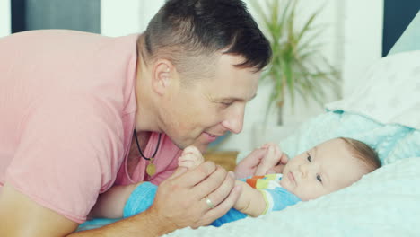 young father playing with his son two months he smiles