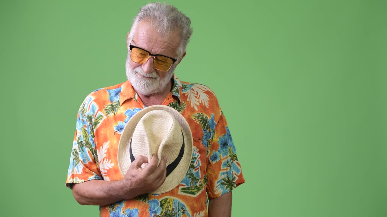 hombre turista barbudo y guapo listo para las vacaciones contra un fondo verde