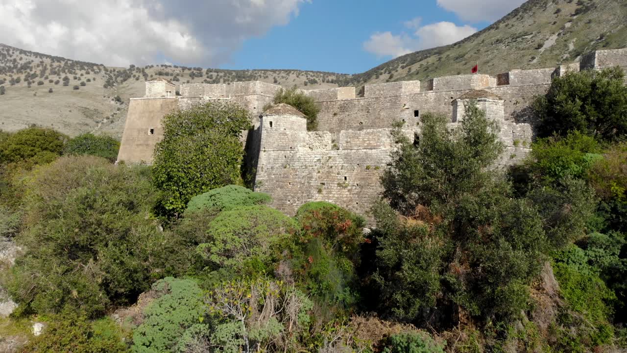 fortaleza rodeada de exuberante vegetación con gruesos muros de piedra construidos a orillas del mar mediterráneo