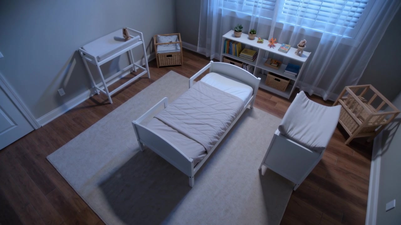Recording ceiling camera capturing white bed in nursery with bassinet, changing table, bookshelf