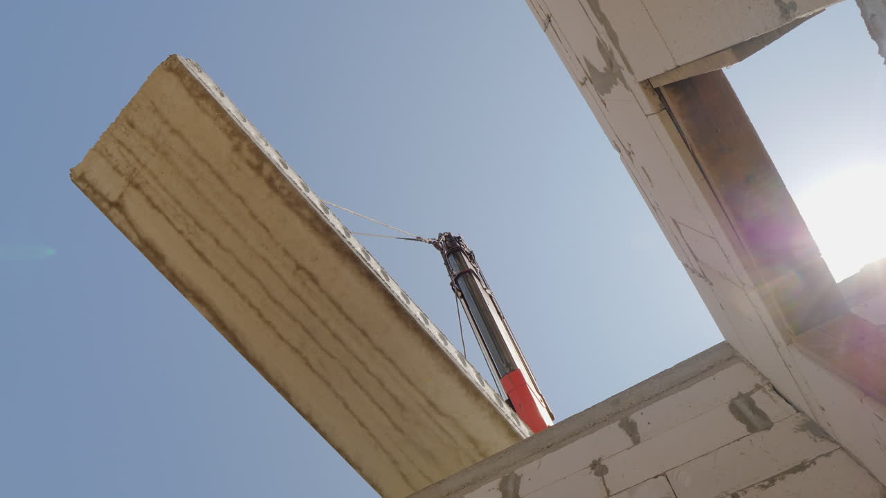 una grúa instala un panel de piso en un edificio de varios pisos una vista inferior