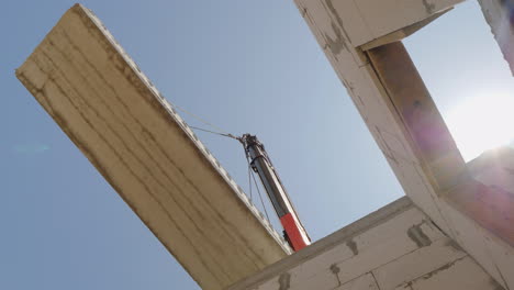 a crane installs a floor panel in a multi-storey building a bottom view