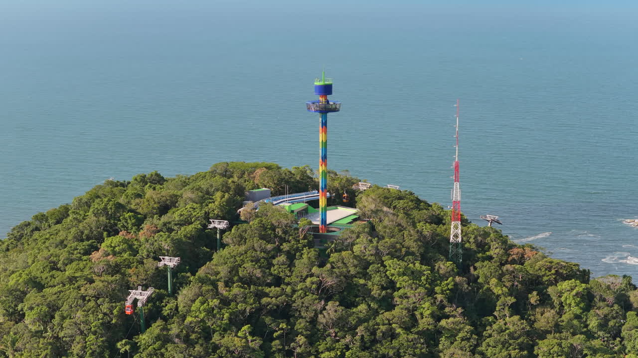 Close-up aéreo do Parque Unipraias com torre colorida e teleféricos em Balneário Camboriú, Brasil.