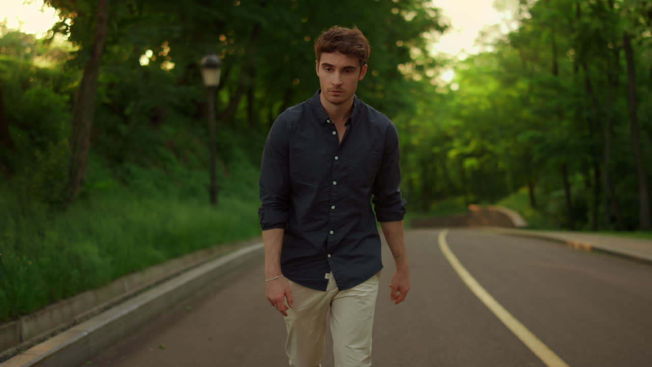 실망한 남자가 도로 밖으로 나가고 있습니다. 심각한 남자가 야외에서  ⁇ 고 있습니다.