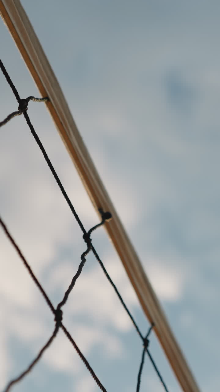 primer plano de una red de voleibol con la pelota jugando sobre ella, bajo un cielo brillante, capturando un momento emocionante en un juego de voleibal al aire libre con un hermoso telón de fondo natural