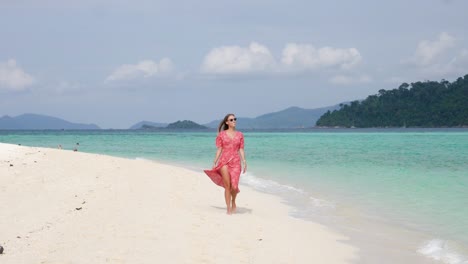 Ultra-slow-motion-shot-of-smiling-young-woman-walking-on-beautiful-beach-on-island-in-Thailand