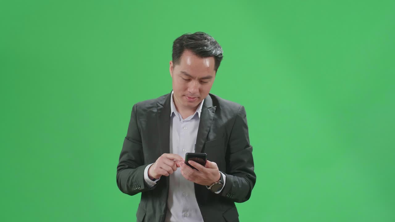 Asian Business Man Use Mobile Phone While Walking On Green Screen Chroma Key