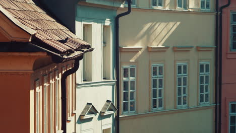 pigeon bird sitting on red roof in center of prague and flies away