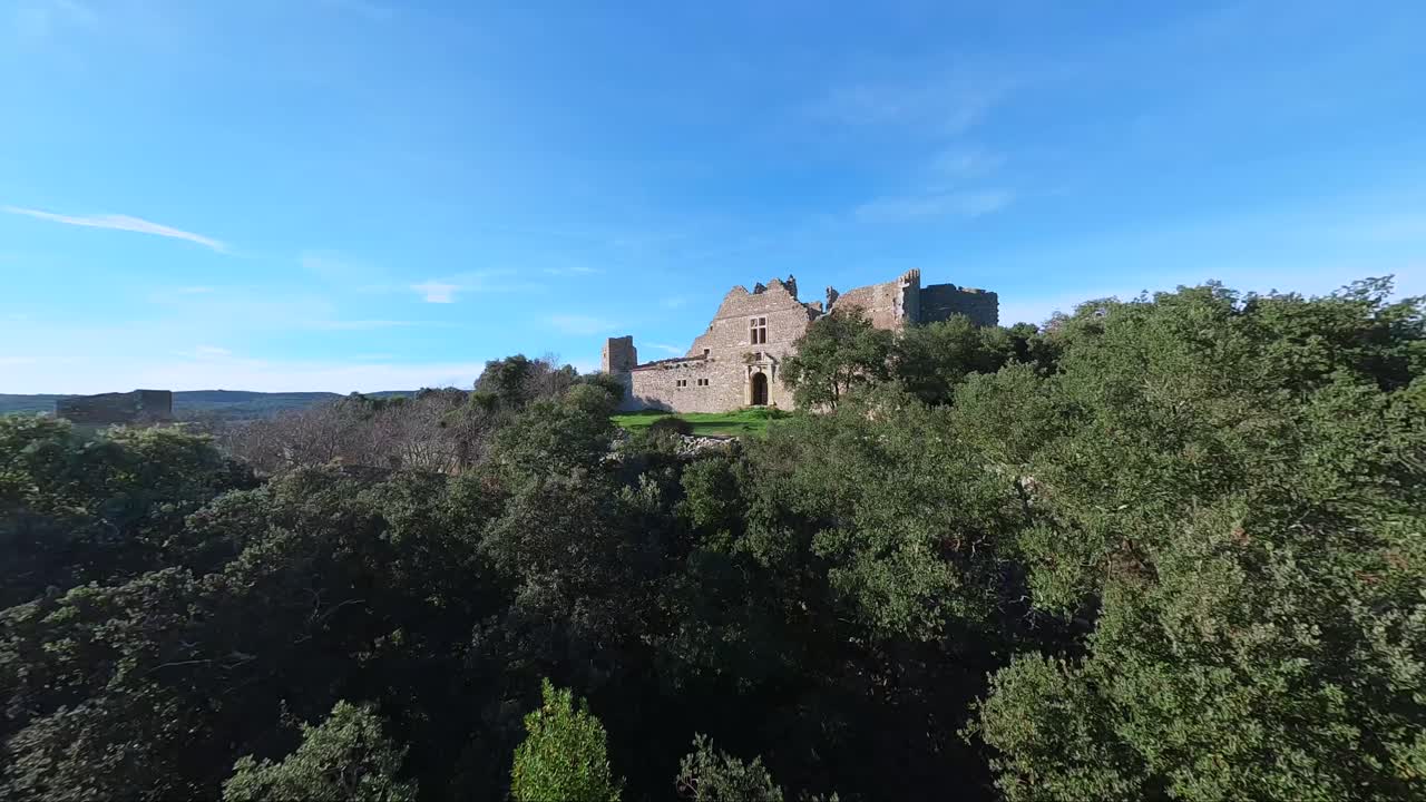 vuelo del dosel del bosque para revelar un castillo en ruinas en el sur de francia.