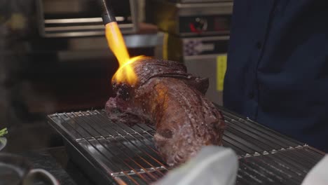 huge beef fillet being torched on a grill