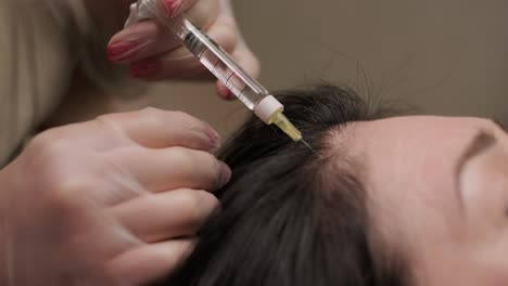 a patient undergoes mesotherapy, receiving targeted injections from a healthcare professional into the scalp to promote hair health